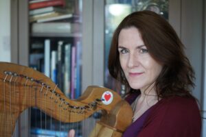 Irish artist and harpist sheila moylan with her harp in the irish cultural centre library