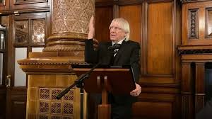 Portrait of Neil Titley standing at a podium