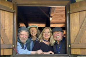 Photo of the Sands family band 3 men 1 women, looking out a shuttered window
