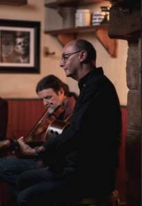 Irish musicians David J Bell Seamie O'Dowd in a pub scene playing music
