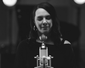 Sinead Willox standing in front of a microphone