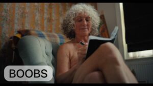 boobs film poster lady sitting on sofa with a book